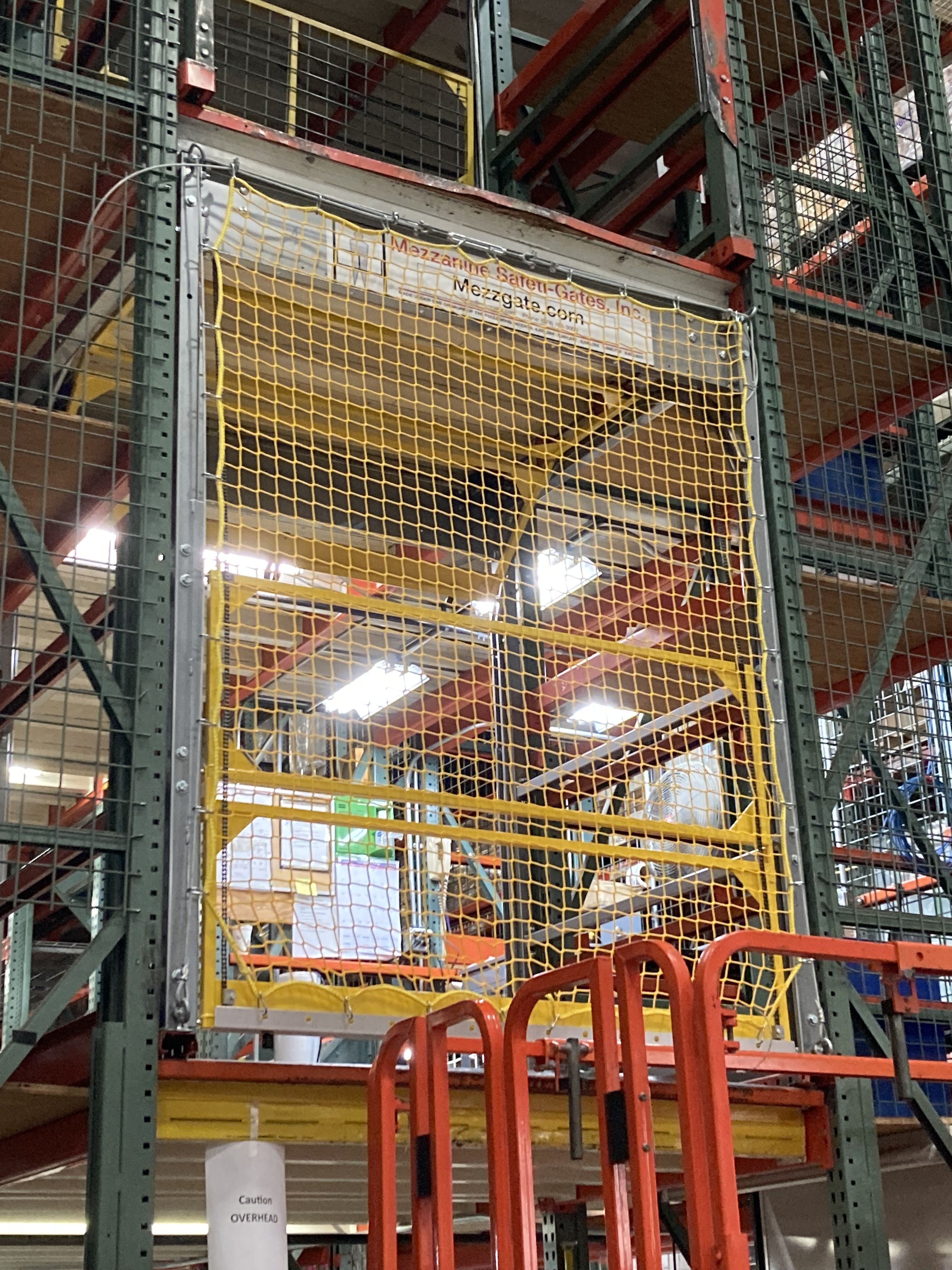 Rack system with pallet drop safety gate and netting from Mezzanine Safety Gates