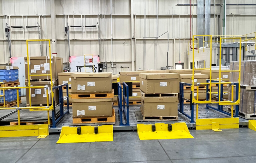 A ground level dual-gate safety system that separates employees working in pallet drop zones from vehicle traffic